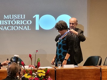 Representando o MHN, a diretora Substituta Aline Montenegro recebe a medalha Tiradentes do deputado Luiz Paulo